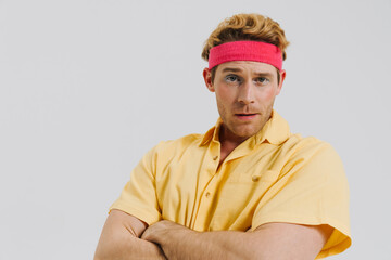 Young white gay man standing over gray wall background