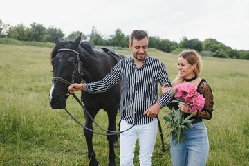 Couple in love having fun in nature. Young couple with a horse.