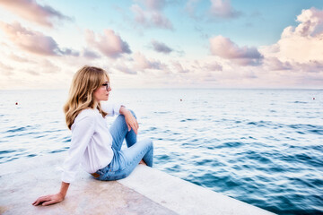 Fototapeta na wymiar Attractive woman sitting by the sea