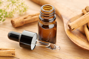 Cinnamon essential oil on bottle on wooden table. Alternative medicine