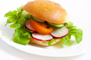 Vegan burger with vegetables on a white plate