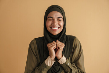Black muslim woman in hijab laughing and gesturing at camera