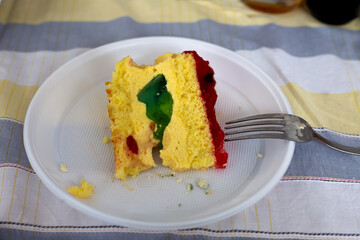 A piece of cake is in a white plate. There is a fork next to it.
