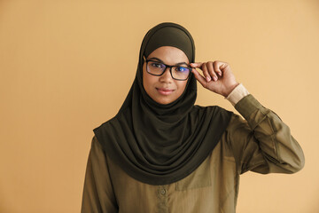 Obraz premium Black muslim woman in hijab posing and looking at camera