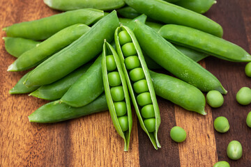 ripe green peas on a wooden chopping board.