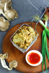 Jamur krispi or crispy fried mushroom served with chili sauce. Marble black background.
