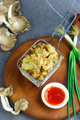 Jamur krispi or crispy fried mushroom served with chili sauce. Marble black background.
