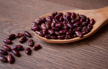 red beans on a wooden spoon. Beans on the table
