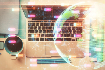 Double exposure of map hologram drawing over study table background with computer. Concept of international network. Top view.