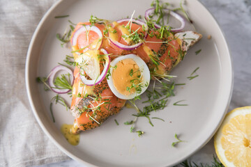 Gravlax Graved Lachs, ein roh gebeizter Fisch auf Toast Brot mit Hovm&auml;stars&aring;s Senf So&szlig;e, Dill, Kresse, Ei, Zwiebel Ringe, Zitrone und Leinen Tuch auf hell Marmor Hintergrund