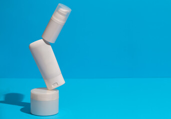 Set of blank white skincare cosmetic products on background with free space for advertising text. Floating empty moisturizer and hygiene bottle.
