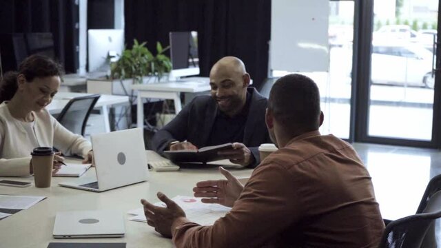 cheerful and disabled african american boss working with coworkers in office