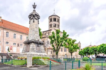 Fototapeta na wymiar Issoire, a town in the land of the volcanoes of Auvergne, France! View of the war memorial in the foreground and the 12th-century Sainte-Austremoine Church in the background 