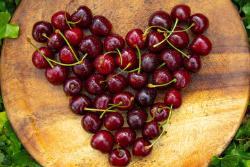 heart of cherries on wooden cutting board