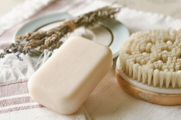 Handmade organic white soap with body brush and aroma herbs close up. Bath accessories on a white...