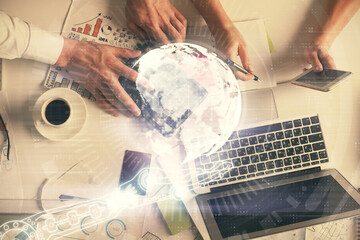 Double exposure of man and woman working together and world map hologram drawing. international network concept. Computer background. Top View.