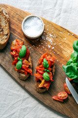 Classic bruschetta with tomatoes on a wooden cutting board.