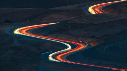 Abwaschbare Fototapete Autobahn in der Nacht Car lights at night on the mountain pass winding road 