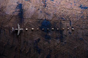 The golden trip. Trail of gold in front of an airplane. Miniature airplane on rustic wood.