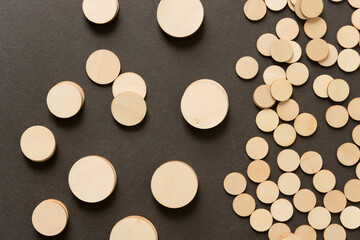 background composed of thin, untreated or natural round wooden shapes - loosely arranged on a dark gray ground - photographed in a top-down style 