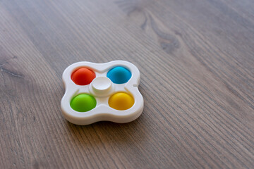 Colorful antistress sensory toy fidget push pop it and spinner simple dimple on the wooden...