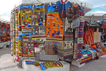Rugs and blankets for sale at an outdoor market in Otavalo, Ecuador.