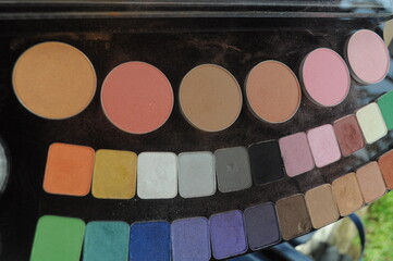 Colorful eyeshadow palette for makeup professionals as cosmetic product samples on black palette