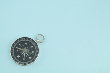 Round black compass on blue background with copy space	