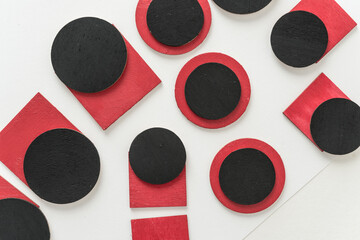 painted black and red shapes on a light background 