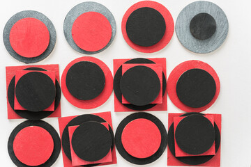 painted black and red shapes on a light background 
