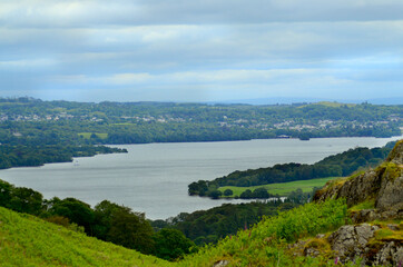 Fototapeta premium Landscape in the lake district. Mountings and lake, rainy day, England. Nature top view from the top of the mountain in the foreground. Lake District Valley