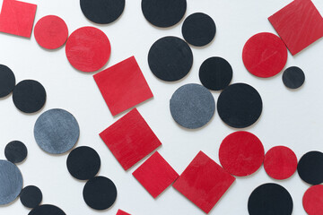 painted black and red shapes on a light background 