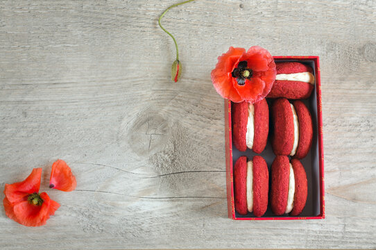 Top view of a decoration of red cookies and poppy flowers. Macaroon cookies with copy space for text