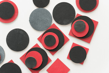 painted black and red shapes on a light background 