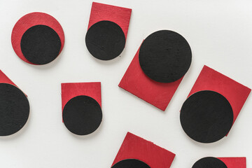 painted black and red shapes on a light background 