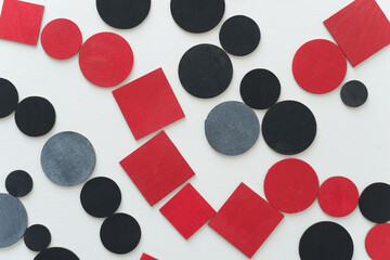 painted black and red shapes on a light background 