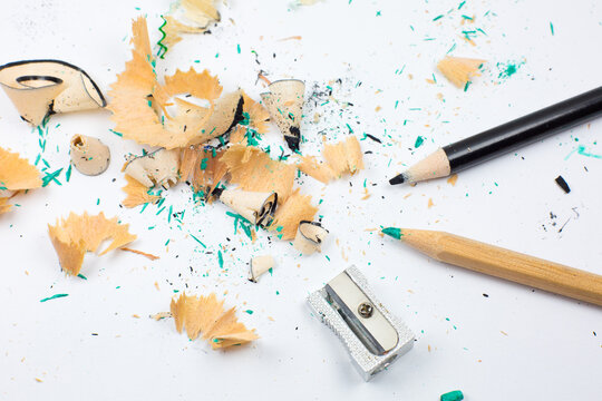 Sharpener and a broken pencil. Shavings and a graphite on white background. Close up, Macro photo. Back to school concept.