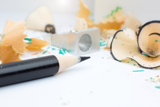 Sharpener and a broken pencil. Shavings and a graphite on white background. Close up, Macro photo. Back to school concept.