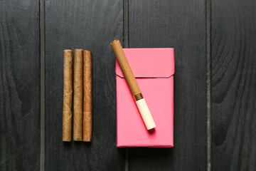 Cigars with pack on dark wooden background