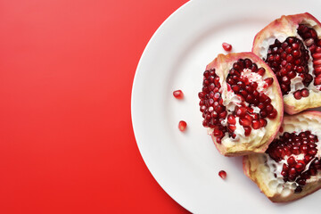 Ripe red pomegranate on a white plate