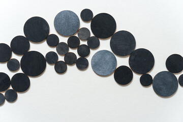 circular wooden shapes hand painted arranged in a loose composition on a light ground - photographed in a top-down orientation