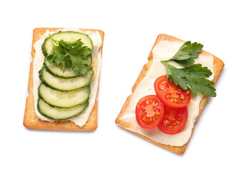 Tasty crackers with cheese, tomatoes and cucumber on white background