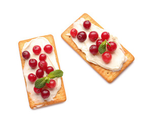 Tasty crackers with cheese and cranberry on white background