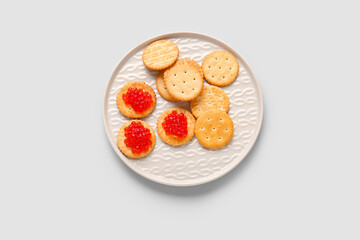 Tasty crackers with red caviar on grey background