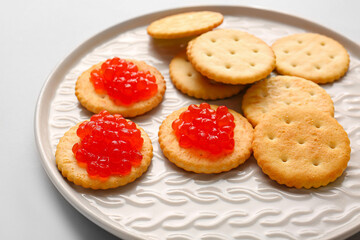 Tasty crackers with red caviar on grey background, closeup