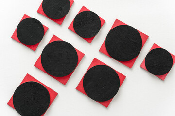 painted black and red shapes on a light background 