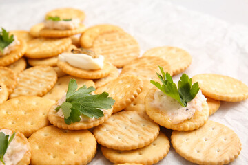 Tasty crackers on baking parchment, closeup