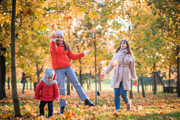 Fototapeta premium Mother and her child girl playing together on autumn walk outdoors.