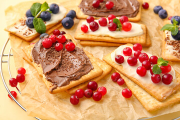 Tasty crackers with berries on table, closeup