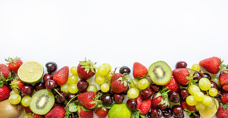horizontal frame from juicy fruits. strawberries, cherries, kiwi, lime and grapes on white background
